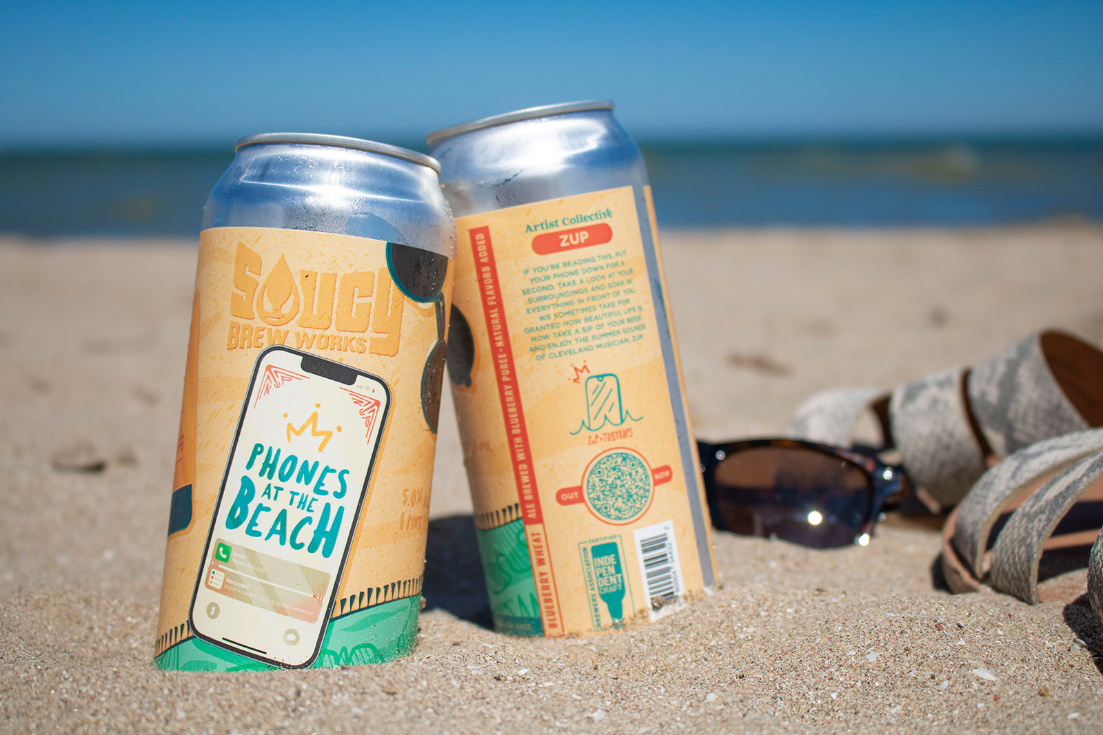 cans of beer in the sand at the beach