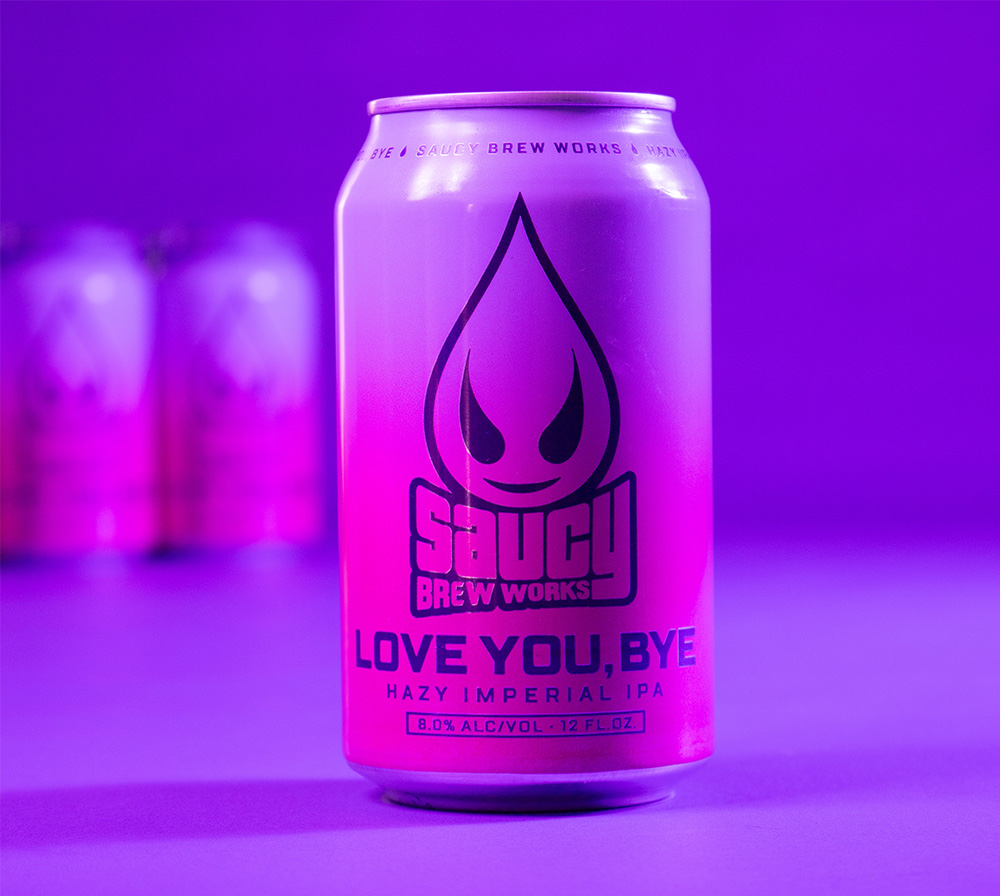 A can of Love You, Bye in front of a 6 pack with glowing purple background.