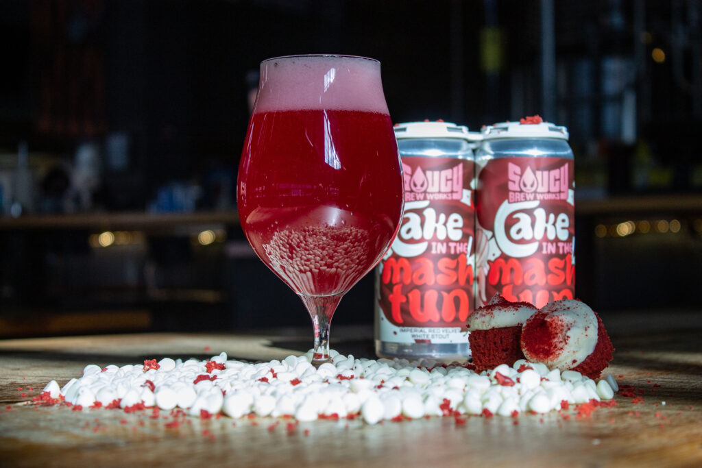 Tulip glass filled with red beer on a table.