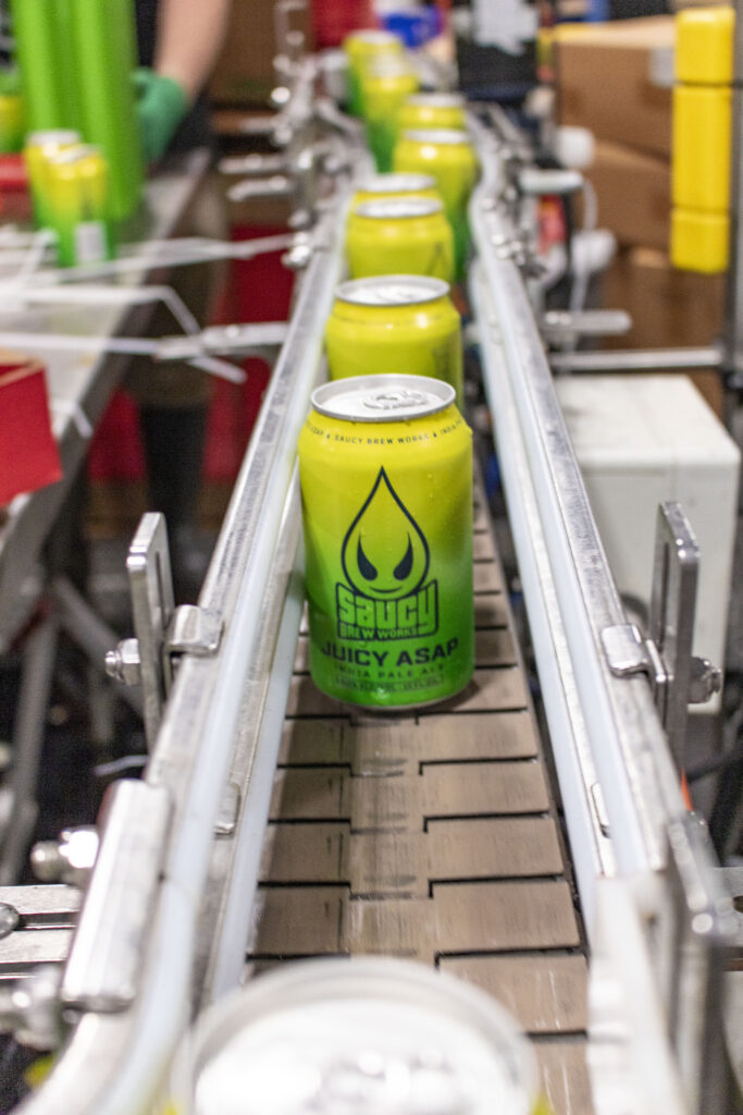 Juicy Asap cans in a row on the canning line.