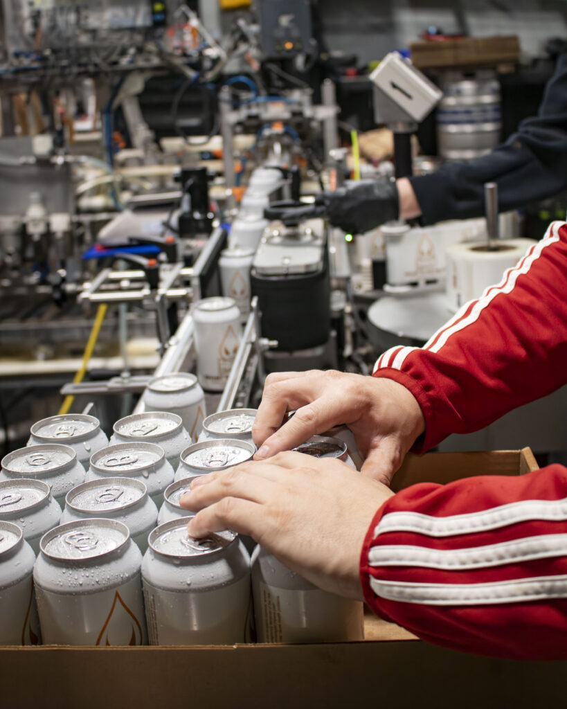 Brewer packaging cans of What's His Nuts.